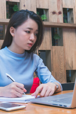 Young,Asian,Female,Student,Studying,In,The,Coffee,Shop,With