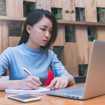Young,Asian,Female,Student,Studying,In,The,Coffee,Shop,With