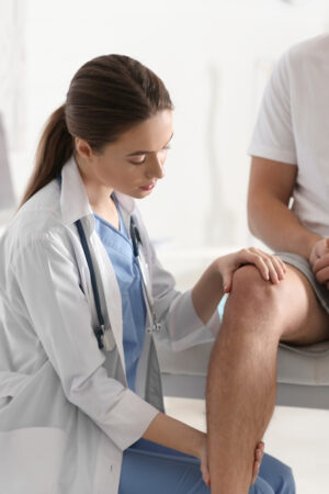 Female,Orthopedist,Examining,Patient’s,Leg,In,Clinic